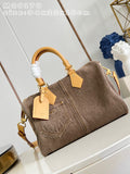 A brown canvas duffel bag with tan leather handles and trim, displayed on a white surface with a decorative background. The image includes a size overlay in the top left corner.