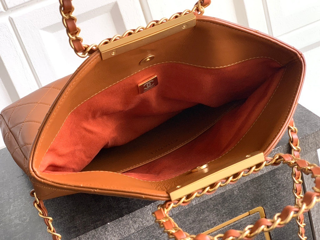 Brown handbag with gold chain handle on a white background