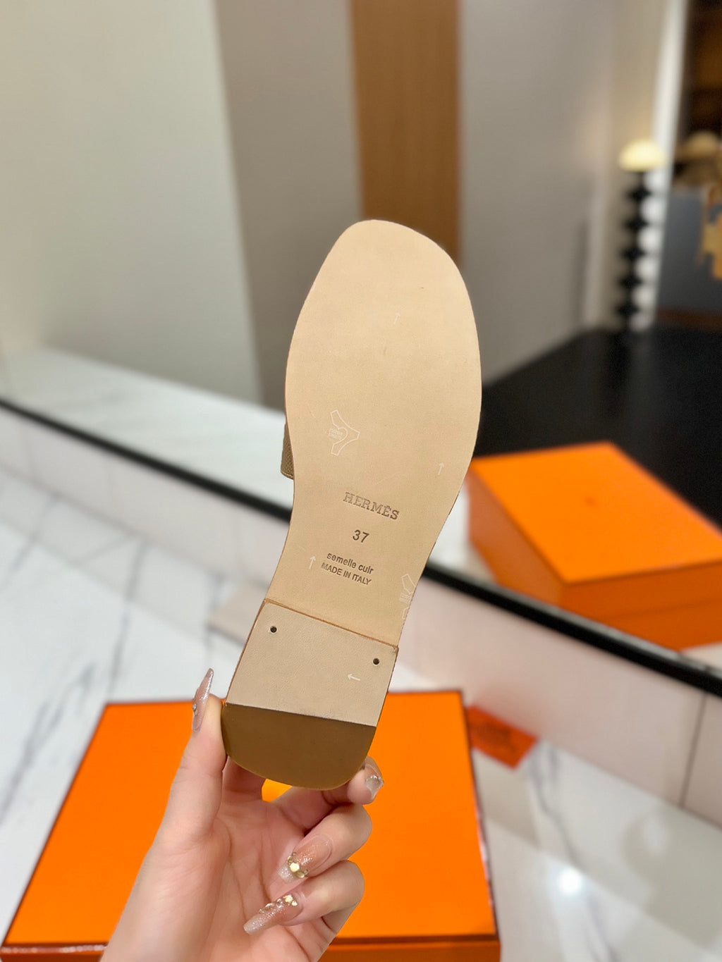 Shoe insole held by a hand with an orange box in the background