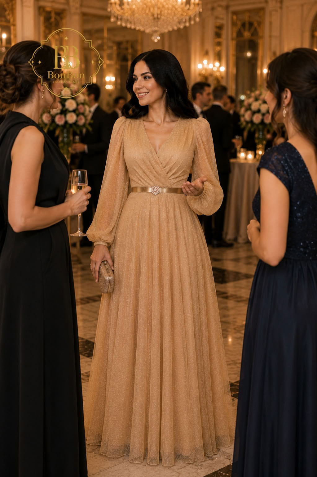 A woman in a champagne beige floor-length tulle gown with a silver belt stands in a grand ballroom, flanked by two other women in formal evening gowns.